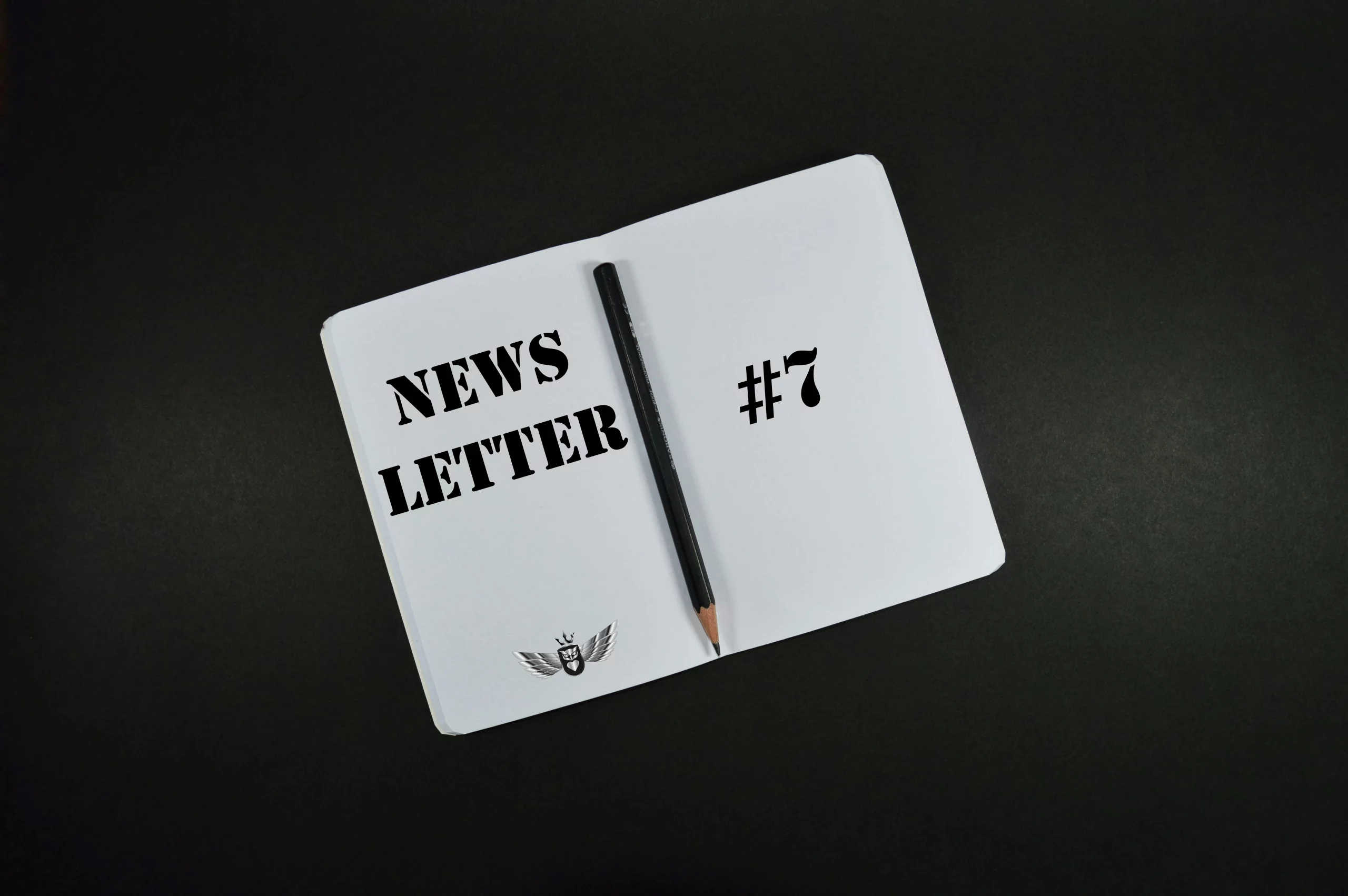 White notebook labeled “NEWSLETTER #7” with pen on black background symbolizing the guts to take action and not waste time